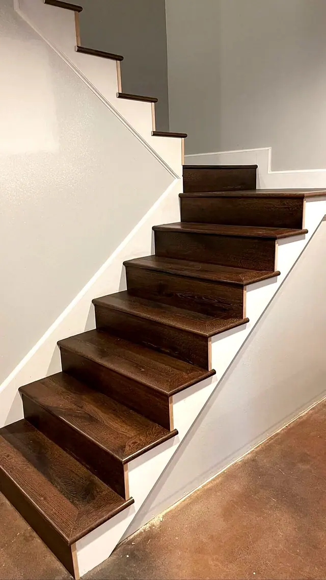 Dark stained wood staircase with white risers and finished trim