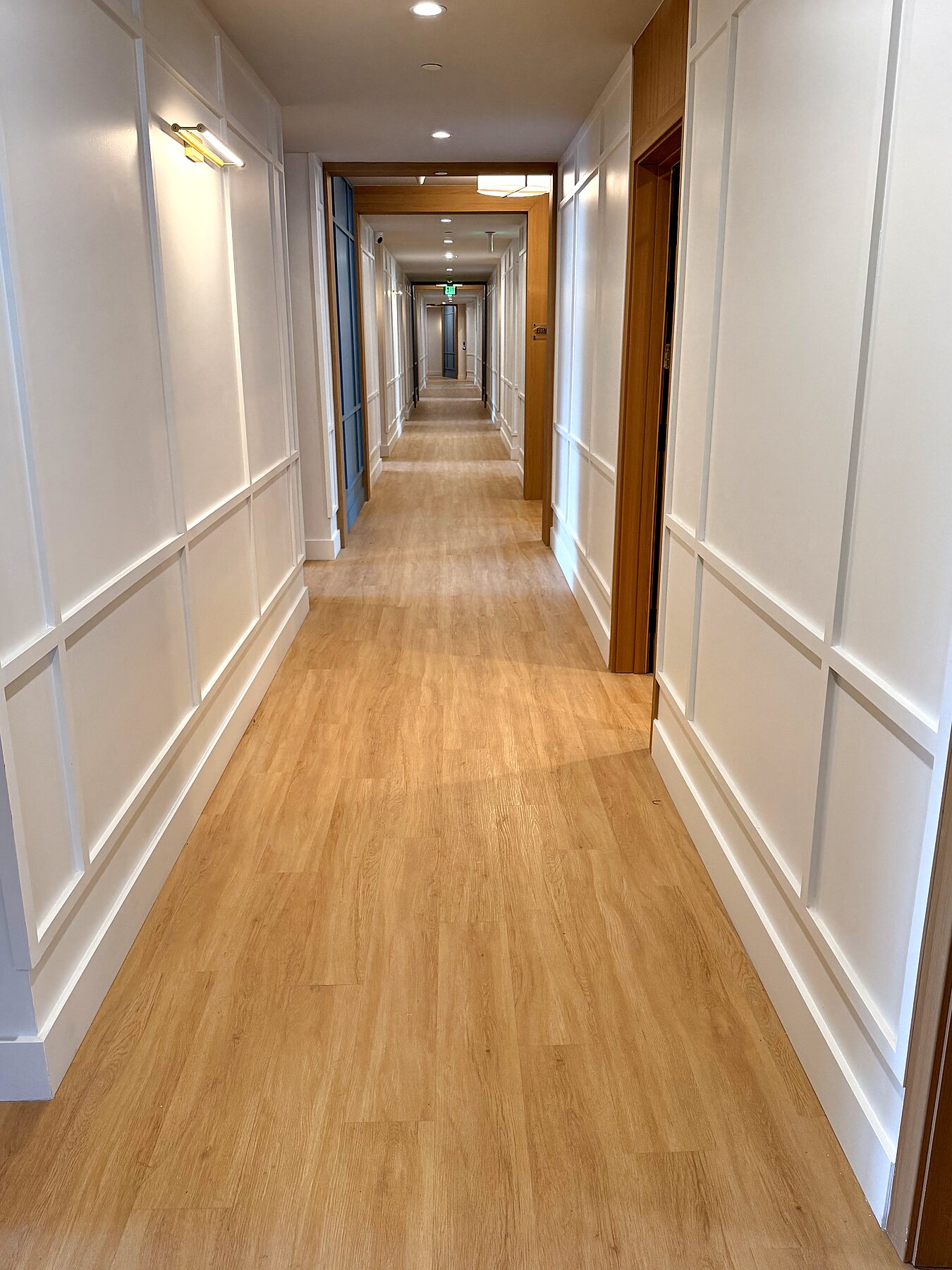 Hallway finish carpentry with white trim, wall paneling, doors, and painted walls by Grain and Stain Renovations in Hendersonville TN